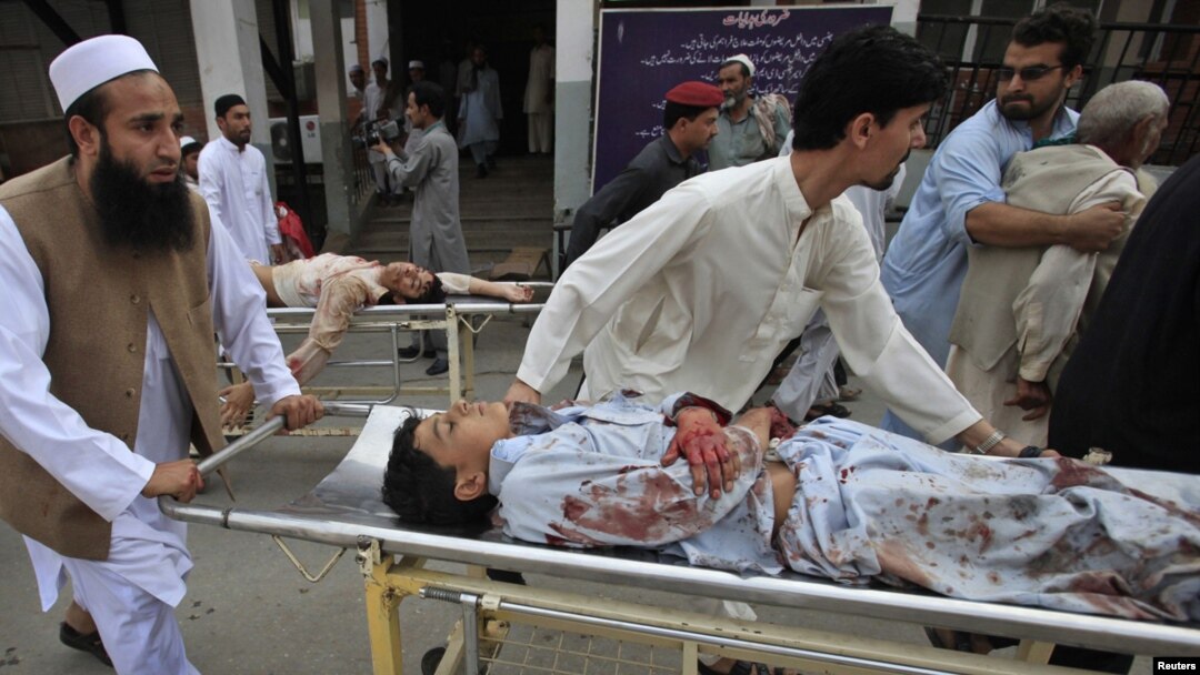 People help injured victims get to the hospital after the blast in Darra Adam Khel