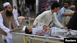 People help injured victims get to the hospital after the blast in Darra Adam Khel