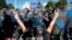 A man flashes victory signs next to a riot police line outside the government headquarters in Bucharest, August 10, 2018.