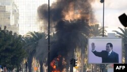 Очаги возгорания на улицах города вследствие столкновений между полицией и демонстрантами. Тунис, 14 января 2011 года.
