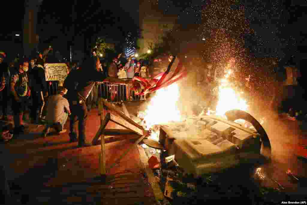 U.S. -- America Protests Washington -- Demonstrators start a fire as they protest the death of George Floyd, Sunday, May 31, 2020, near the White House in Washington. Floyd died after being restrained by Minneapolis police officers