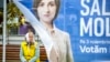 An woman sits on a street bench in downtown Chisinau behind a campaign tent for President Maia Sandu on October 31. 