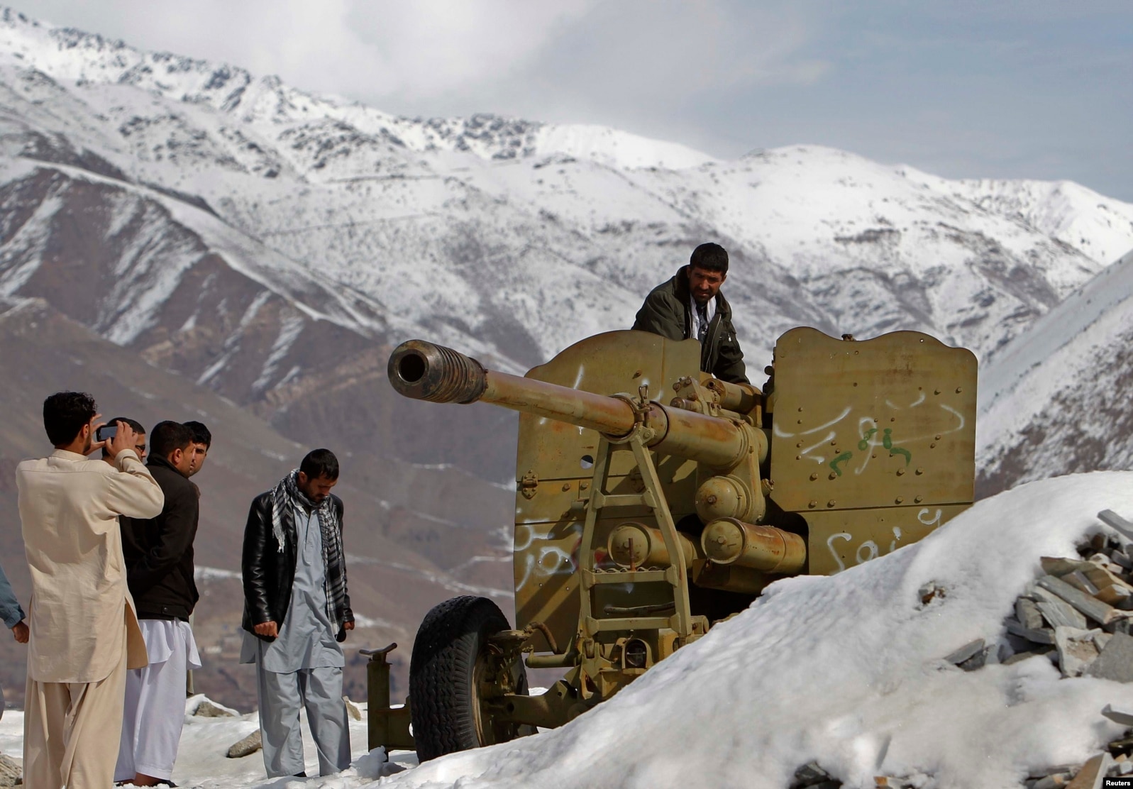 Afghans look at destroyed Soviet artillery at a junkyard in Panjshir Province, north of Kabul, in 2014.
