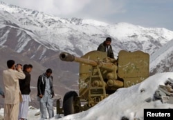 Afghans look at destroyed Soviet artillery at a junkyard in Panjshir Province, north of Kabul, in 2014.
