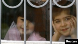 Children look out a window at an orphanage in the southern city of Rostov-na-Donu.
