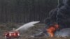 A firetruck sprays water on the wreckage of a crashed Mi-28 helicopter in which one pilot was killed on August 2 near Ryazan, Russia. (Reuters)