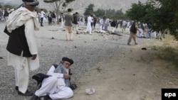 FILE: An injured Afghan elder makes a phone call at the scene of three bombings at a funeral in Kabul on June 3.
