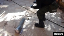 A UN chemical weapons expert gathers evidence at one of the sites of an alleged poison-gas attack in the southwestern Damascus suburb of Moadamyeh on August 26. 