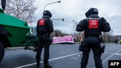 Policija ispred demonstranata koji blokiraju put protestujući protiv konvencije krajnje desničarske stranke Alternativa za Nemačku (AfD), u Rizi, Njemačka, 11. januara.