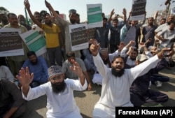 Supporters of a Pakistani religious group chant slogans while blocking a main road at a protest after the court decision in Karachi on October 31.