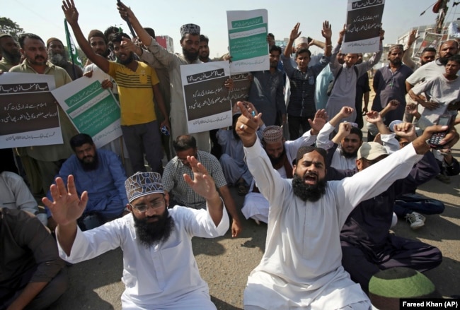 Supporters of a Pakistani religious group chant slogans while blocking a main road at a protest after the court decision in Karachi on October 31.