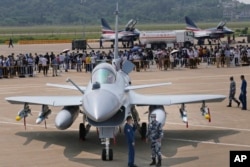 Китайські військовослужбовці стоять біля винищувача J-10C під час 13-ї Китайської міжнародної авіаційної та аерокосмічної виставки, також відомої як Airshow China, у вересні 2021 року