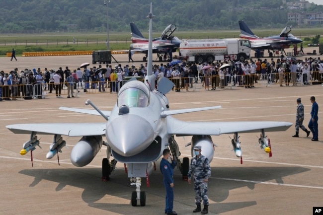 Personeli ushtarak kinez pranë një avioni luftarak J-10C. Shtator, 2021.