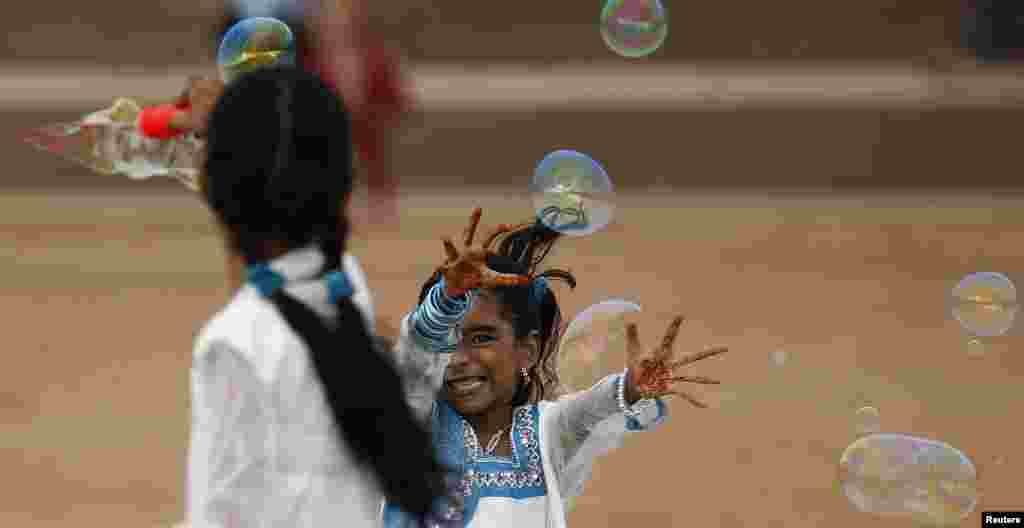 Girls play with bubbles as they celebrate the Eid al-Fitr festival marking the end of Ramadan, the holiest month in the Islamic calendar, at Galle Face Green in Colombo, Sri Lanka. (Reuters/Dinuka Liyanawatte)