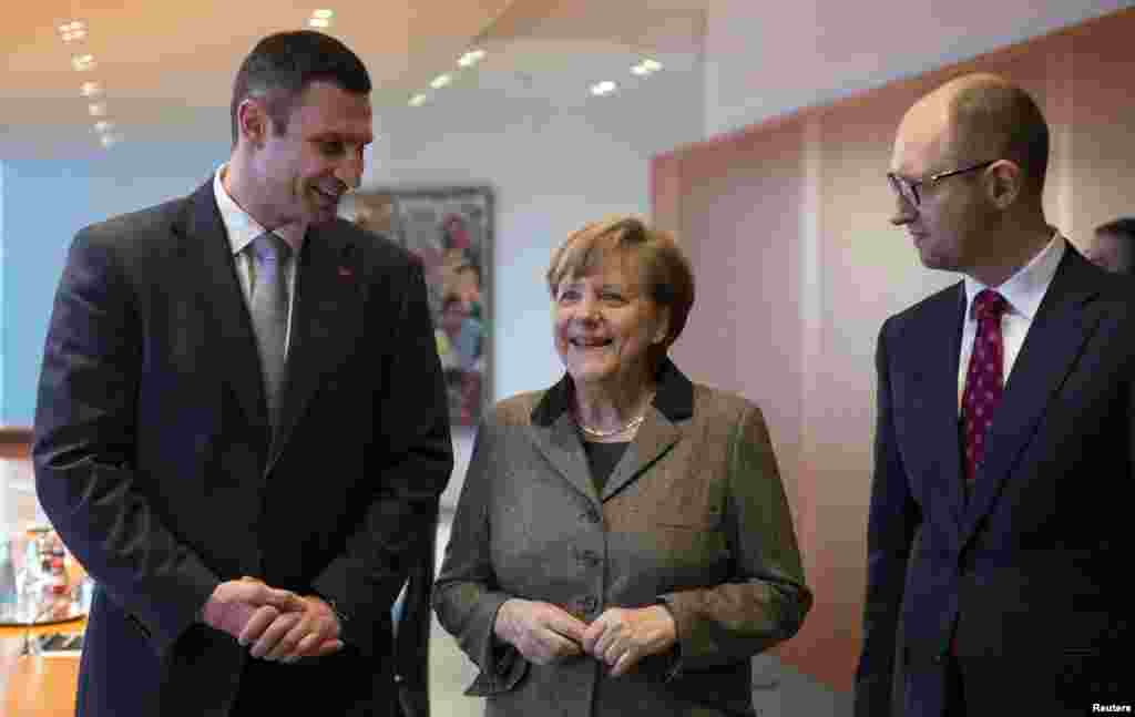 Cancelarul german Angela Merkel la întîlnirea cu liderii opoziției ucrainiene, la Berlin, Vitali Kliciko (stg.) și Arseni Iațeniuk la 17 februarie 2014.