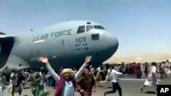 Afganët duke vrapuar pas një aeroplani amerikan të mallrave, më 16 gusht, 2021.