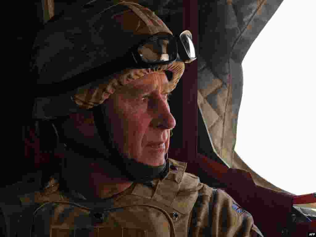 Britain's Prince Charles rides in a British military helicopter en route to Lashkar Gah, Afghanistan. - Prince Charles arrived in Afghanistan on March 25 on a surprise visit to meet with British soldiers serving in southern Helmand Province. Photo by AFP