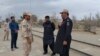 A Pakistani border security official (R) and an Iranian border official meet at Zero Point in the Pakistan-Iran border town of Taftan, October 16, 2018