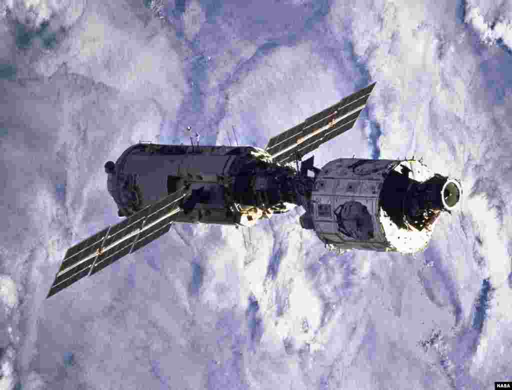 Blanketing clouds form the backdrop for this scene of the connected "Zarya" and "Unity" modules after having been released from the cargo bay of the space shuttle "Endeavour" a bit earlier.