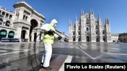 Працівник у захисному одязі дезінфікує площу П’яцца-дель-Дуомо (Соборна площа), Мілан, 31 березня 2020 року