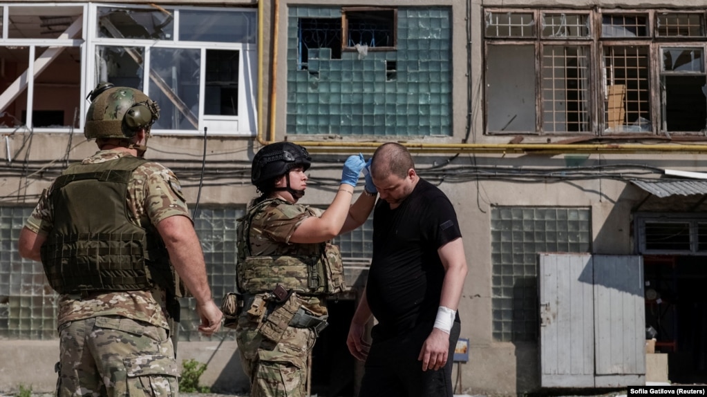 Пораненому внаслідок російської атаки чоловіку надають першу допомогу, Харків, 15 липня 2026 року