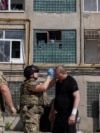 Пораненому внаслідок російської атаки чоловіку надають першу допомогу, Харків, 15 липня 2026 року