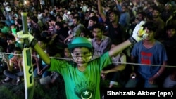 Fans in Karachi watch on a giant-screen TV a match played by a national team in London in June.