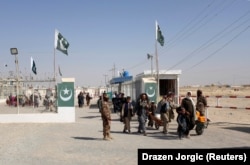 Pakistani soldiers keep guard as citizens return from Afghanistan at the border-crossing town of Chaman in October