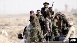 Rebel forces on the back of a pick-up truck in Ajdabiya