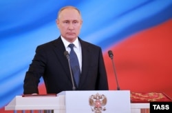 Putin takes the oath of office on a copy of the Russian Constitution.