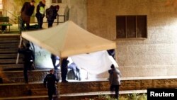 Police cover a body after a shooting outside an Islamic center in central Zurich on December 19.