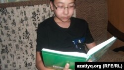 Ученик 7-го класса Дарын Дастанулы читает книгу. Алматы, 10 июня, 2014 года. 