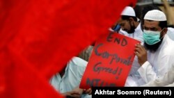 An activist, wearing a protective mask as a preventive measure against the spread of the coronavirus disease (COVID-19), attends a rally demanding improvements in the working conditions during the International Labour Day, in the southern seaport city of Karachi on May 1.