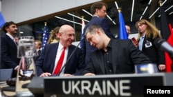 Міністр оборони Великої Британії Джон Гілі розмовляє з міністром оборони України Михайлом Федоровим під час засідання групи Рамштайн в штаб-квартирі Альянсу в Брюсселі, Бельгія, 12 лютого 2026 року.