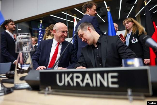 Міністр оборони Великої Британії Джон Гілі (ліворуч) розмовляє з міністром оборони України Михайлом Федоровим під час засідання Контактної групи з питань оборони України в штаб-квартирі НАТО в Брюсселі, 12 лютого 2026 року