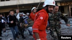 Liban - Pjesëtarët e Kryqit të Kuq bashkë me ushtarët evakuojnë një grua të lënduar nga shpërthimi në paralagjen Bir Hassan të Bejrutit, 19 shkurt, 2014