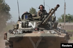 Az oroszbarát csapatok katonái egy gyalogsági csapatszállító járművön Popasznában