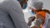 Një punëtore mjekësore merr një dozë të vaksinës Oxford / AstraZeneca kundër sëmundjes së koronavirusit në spitalin e Kievit, 15 mars 2021.
