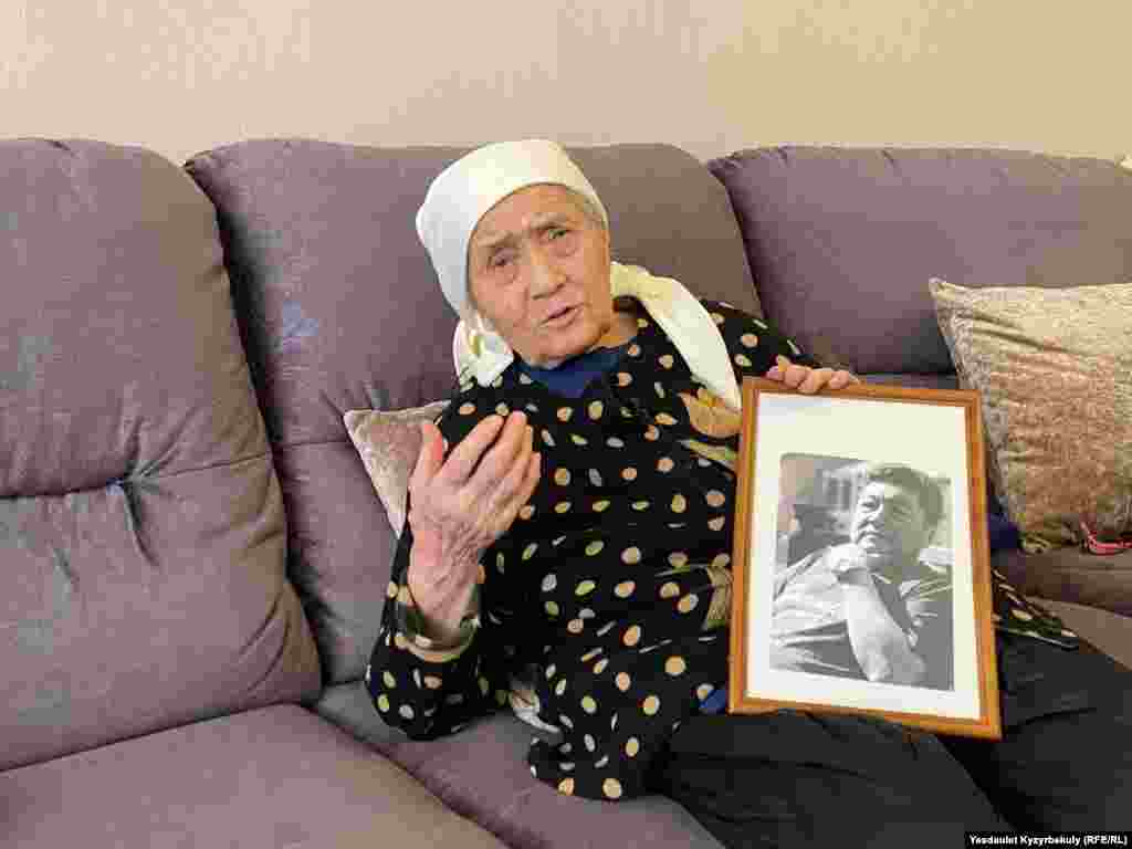Жасы тоқсанға келген Сақыш Ережепқызы Қытайдың Шыңжаң аймағында қамауда отырған ұлы Қанат Ережептің портретін ұстап отыр. Қазақстанда Қытайға барып ұсталып қалған туыстарына араша сұрап наразылық білдіргендер көп. Алматы, 17 ақпан, 2025 жылФото авторы: Азаттықтың Қазақ қызметі.