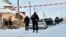 An armed policeman stands guard as police experts examine the scene of the incident in the small town of Knyazichi, some 30 kilometers east of Kyiv, on December 4.