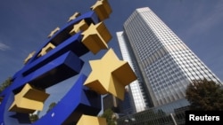 Здание Европейского Центробанка с установленным рядом изображением логотипа единой европейской валюты - евро