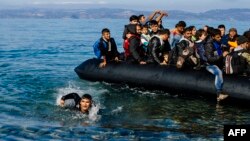 Беженцы и мигранты на резиновой лодке прибывают из Турции на греческий остров Лесбос после пересечения Эгейского моря. 13 октября 2015 года.