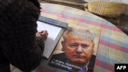 Žena se potpisuje u knjigu žalosti za Slobodana Miloševića