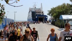 Российские туристы сходят с парома в крымском городе Керчь. Август 2014 года