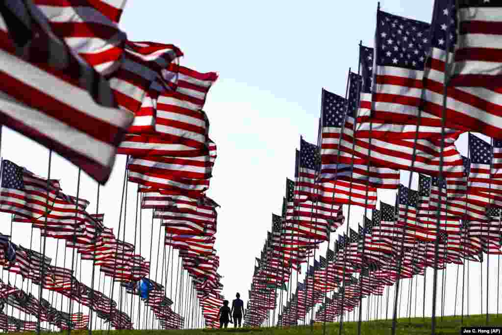 Студенты Университета Пеппердайна идут вдоль американских флагов, установленных в память о жертвах терактов 11 сентября 2001 года в рамках ежегодной мемориальной церемонии. Малибу, Калифорния.&nbsp;(AP Photo&nbsp;/&nbsp;Jae C. Hong)
