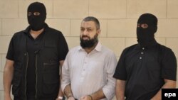 Security officials escort arrested terror suspect Naeem Bukhara in Karachi on February 12.