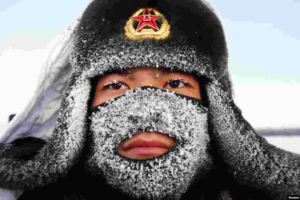 Frost covers the mask and part of the hat of a soldier of China's People's Liberation Army as he stands guard near the border of China and Russia in Heilongjiang Province.(Reuters)