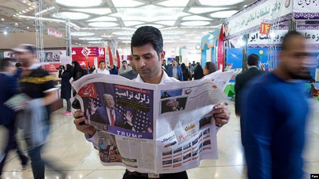 A man reading a newspaper in Tehran.