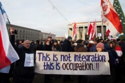 Учасники протесту в Мінську несуть плакат, на якому напиано: «Це - не інтеграція. Це - окупація».