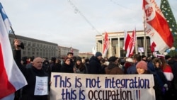 Протестующие в Минске несут плакат с надписью «Это не интеграция, это оккупация»